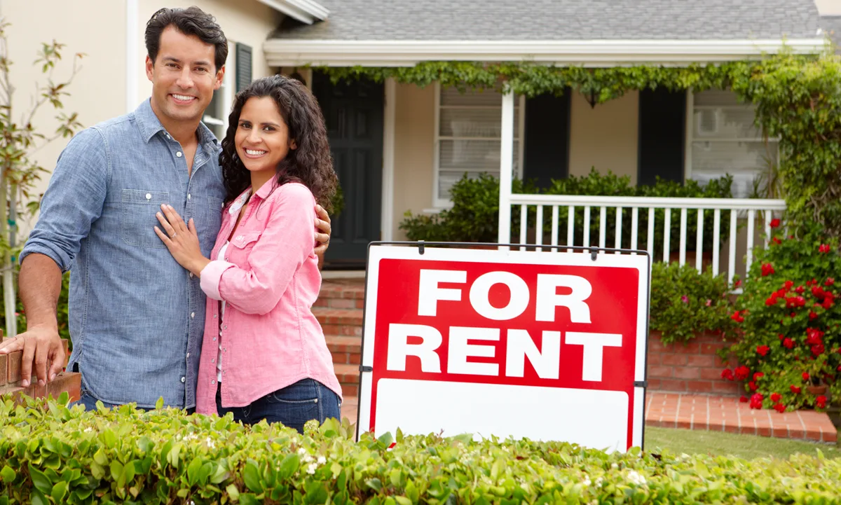Renters standing outside a rental home with confidence because the rental property is covered by a home warranty.