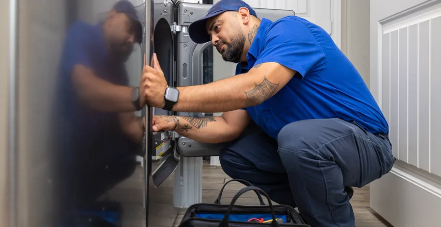 Sears Home Services technician performing clothes dryer maintenance.