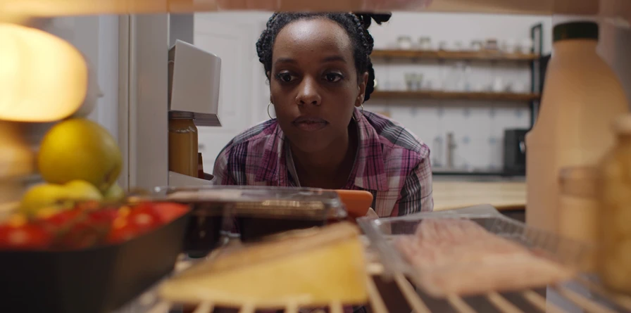 woman looking into a fridge that isn't working