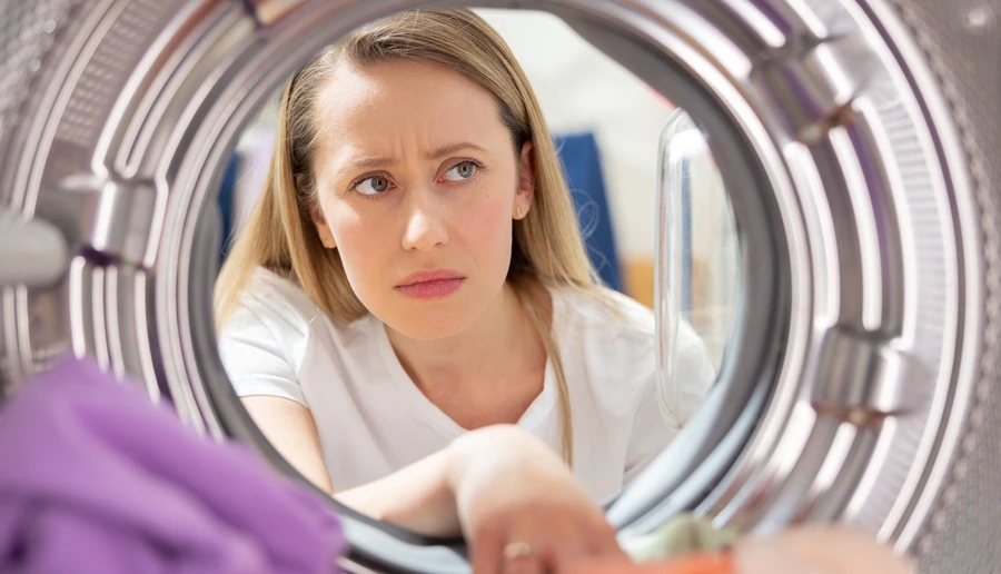 woman looking into the dryer and knowing the dryer has problems
