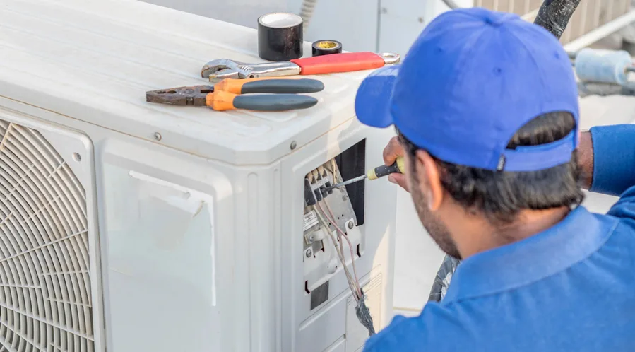 HVAC technician installing a new heat pump that qualifies for HEEHRA rebates