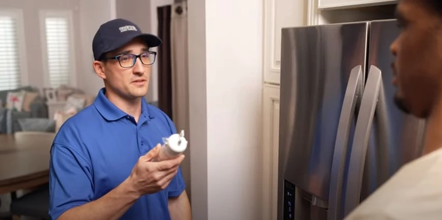 Sears Technician repairing a refrigerator that isn't cooling