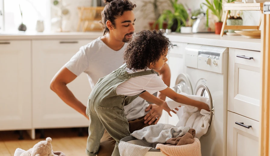 homeowner and child loading a washer and learning how does a washer work