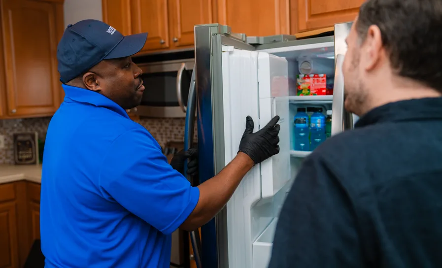 homeowner discussing whether it's worth repairing a refrigerator with a Sears Technician