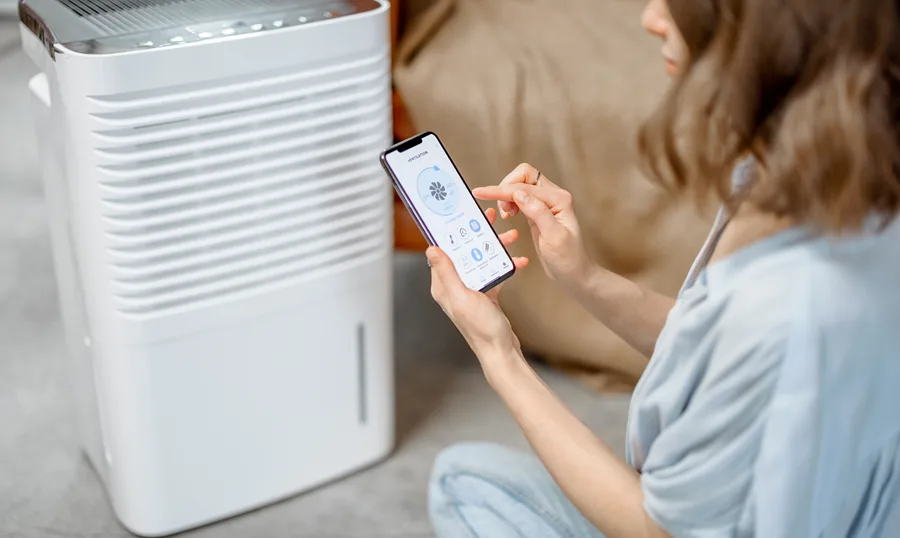 A homeowner adjusting the settings on a dehumidifier