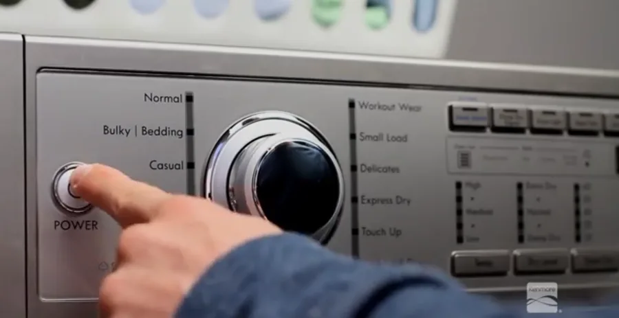 Homeowner setting the cycle on a Kenmore dryer for blog Laundry Cycles Explained: Dryer Edition