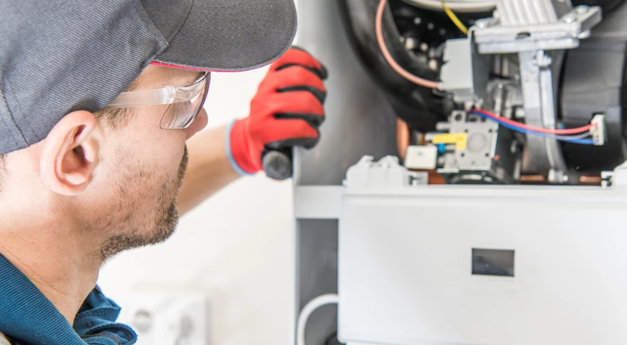 technician evaluating a furnace motor to determine the cost of replacement