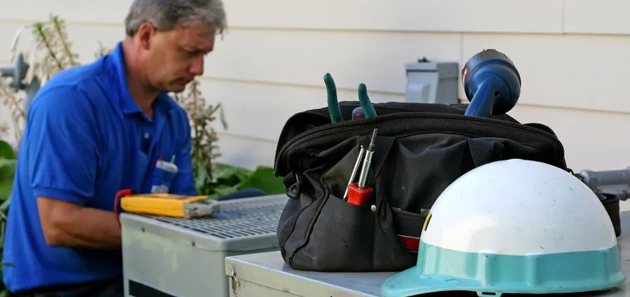 Sears Technician tuning up a central air conditioner
