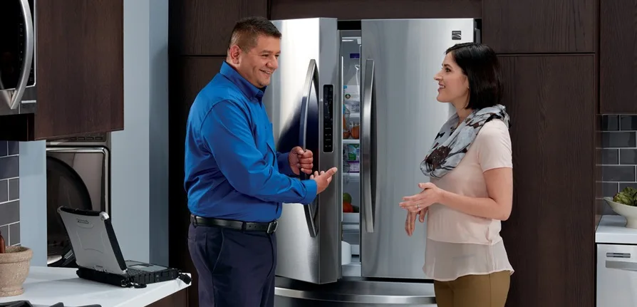 Sears Technician maintaining a refrigerator in a home