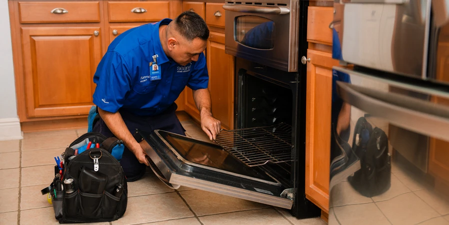 Sears technician repairing an oven